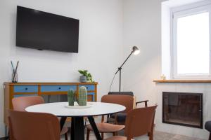 a living room with a table and a tv on a wall at Dragonfly affittacamere in Motta Montecorvino