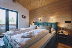 sypialnia z dużym łóżkiem i drewnianą ścianą w obiekcie Premium Apartments Areit by we rent, SUMMERCARD INCLUDED w mieście Zell am See