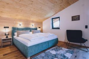 sypialnia z dużym łóżkiem i krzesłem w obiekcie Premium Apartments Areit by we rent, SUMMERCARD INCLUDED w mieście Zell am See