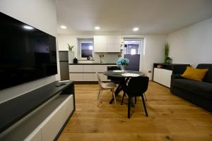 uma cozinha e sala de estar com uma mesa e um sofá em Poseidon Apartment em Izola