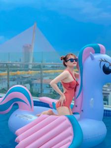 a young girl in a swimsuit standing on an inflatable at Merry Land Hotel Da Nang in Da Nang