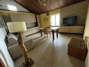 a living room with a couch and a table and a television at Il Vecchio Fienile in Millesimo