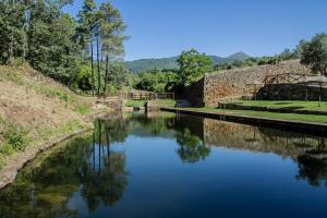 a river with a bridge in the background at RAICES Casa Rural in Torre de Don Miguel
