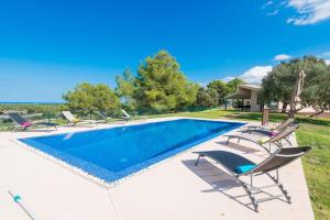 ein Swimmingpool mit Liegestühlen neben einem Haus in der Unterkunft Finca SON VADOR by Mallorca Villa Selection in Santa Margalida
