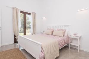 ein weißes Schlafzimmer mit einem Bett und einem Fenster in der Unterkunft Finca SON VADOR by Mallorca Villa Selection in Santa Margalida + 37 Fotos