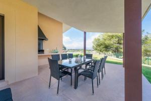 ein Esszimmer mit einem Tisch und Stühlen auf einer Terrasse in der Unterkunft Finca SON VADOR by Mallorca Villa Selection in Santa Margalida