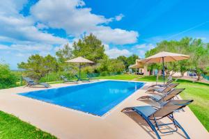 ein Swimmingpool mit Stühlen und Sonnenschirmen in der Unterkunft Finca SON VADOR by Mallorca Villa Selection in Santa Margalida