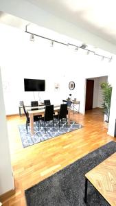 uma sala de estar com uma mesa e cadeiras e uma televisão em Superbe appartement en centre-ville, 20min de Paris, 5 min d'Enghien em Saint-Gratien