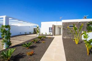 a white building with a courtyard with plants at Villa Balandra in Playa Blanca