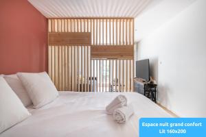 a bedroom with a white bed and a television at SUD PASSION - Ferrer Nine - cosy avec balcon in Gardanne +43 photos