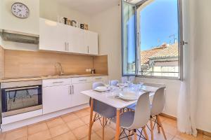 uma cozinha com mesa e cadeiras e um relógio em LE REGORDANE - Appartement 4 personnes - Centre WiFi Cosy em Saint-Gilles