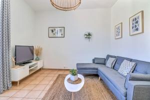 a living room with a blue couch and a tv at LE REGORDANE - Appartement 4 personnes - Centre WiFi Cosy in Saint-Gilles