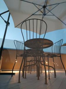 uma mesa e cadeiras sentadas sob um guarda-sol em B&B Del Corso em Scafati