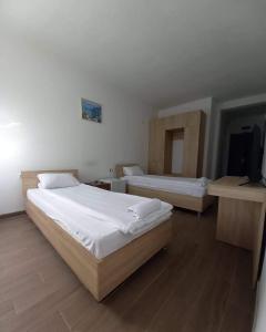 a bedroom with two beds and a flat screen tv at Vila Oska in Vinica