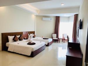 Duy Tân Quảng Bình Hotel & Resort في دونغ هوي: غرفه فندقيه سريرين وتلفزيون