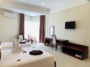 a hotel room with two beds and a television at Duy Tân Quảng Bình Hotel & Resort in Dong Hoi +16 photos