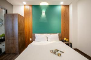 Un dormitorio con una cama grande con una pared azul. en LÁ HOTEL RIVERSIDE, en Ho Chi Minh