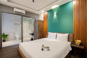 Un dormitorio con una cama grande con una pared azul. en LÁ HOTEL RIVERSIDE, en Ho Chi Minh 23 fotos más