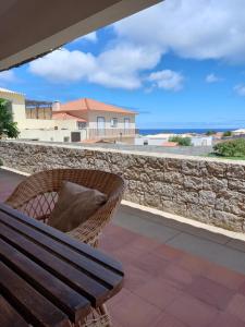 a bench on a patio with a view of the ocean at Quintinha das Lombas in Porto Santo