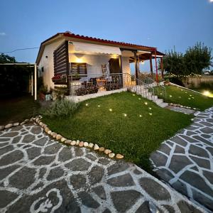 a house with a patio and a grass yard at Anastasias Cottage in Nea Irakleia