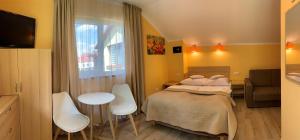a bedroom with a bed and a table and chairs at Willa Słoneczna in Okuninka +97 photos