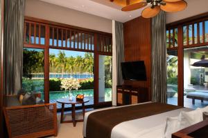 Sanya LUHUITOU Resort & Spa في سانيا: غرفة نوم بسرير وإطلالة على المسبح