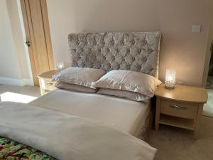 1 dormitorio con 1 cama con cabecera y mesa en The Gables en Haworth