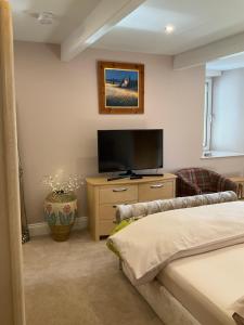 a bedroom with a flat screen tv and a bed at The Gables in Haworth