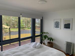 a bedroom with a bed and a view of a balcony at The Beachcomber in Sanctuary Point