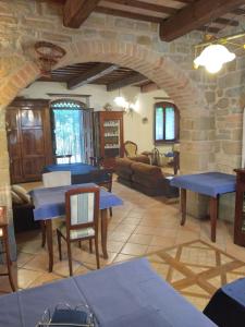 een woonkamer met blauwe tafels en een stenen muur bij Casale Giuncheto in Pilonico Paterno