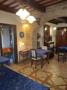 um quarto com uma mesa e cadeiras e uma parede de pedra em Casale Giuncheto em Pilonico Paterno