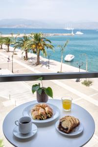 a table with two plates of pastries and a cup of coffee at Agamemnon Hotel in Nafplio