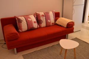 a red couch with pillows on it in a living room at Apartments Elli in Korčula