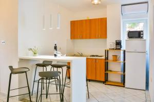 a kitchen with a white refrigerator and bar stools at Holiday Apartments Soparin in Senj