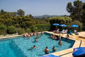 um grupo de pessoas a nadar numa piscina em Les Arbousiers Village Hôtel Provençal em La Roquebrussanne