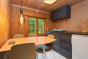 a kitchen with a table and chairs and a television at Ljoshaugen Camping in Dombås
