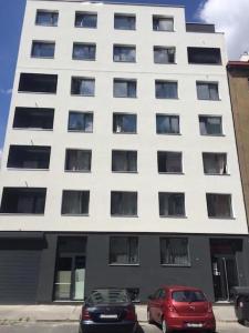 two cars parked in front of a white building at Hotel Harfa in Prague