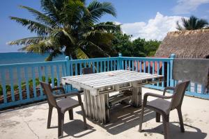 una mesa de madera y sillas en un balcón con vistas al océano en Cabaña CasaMare en Rincón