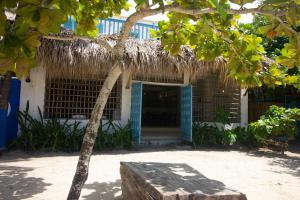 un edificio con techo de paja y un árbol en Cabaña CasaMare en Rincón