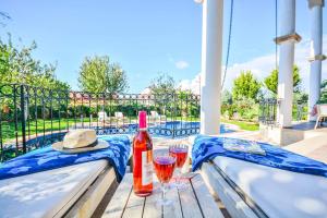 a bottle of wine and two glasses on a table at Villa Pegasus Evi in Ovacik