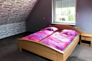 Ce lit se trouve dans une chambre dotée d'une couverture rose. dans l'établissement FewoJanssen, à Apen