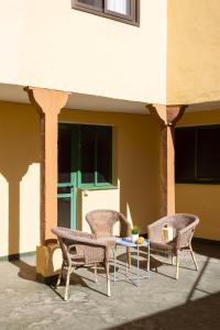 three chairs and a table in front of a building at Home2Book Arafo Rural Escape BBQ in Arafo