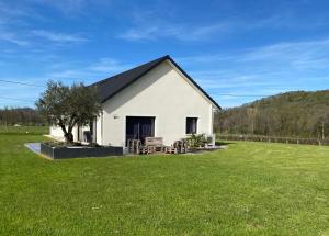 ein weißes Haus mit einem großen Rasenhof in der Unterkunft Maison de Campagne in Brignac-la-Plaine