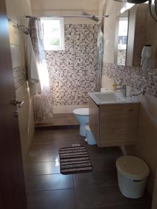 a bathroom with a sink and a toilet and a window at Ionian Golden Sun in Valanidorachi
