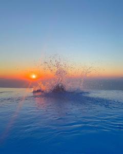 a splash of water in the ocean at sunset at Luna Rossa in Imerovigli