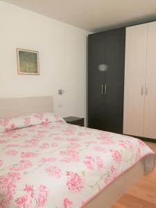 een slaapkamer met een bed met een roze bloemenbed bij Casa Cappello in Malè