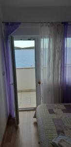 ein Schlafzimmer mit Bett und Meerblick in der Unterkunft Apartments Luka in Sevid
