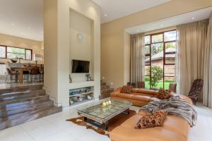 a living room with two couches and a table at Lejwe La Metsi Self-Catering Villa in Bela-Bela