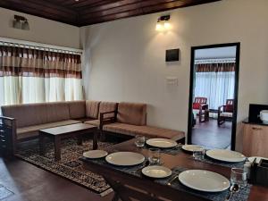 a living room with a table and a couch at Green Veil Cottages in Pīrmed