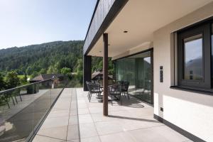 a balcony of a house with a table and chairs at VANEA - Alp Relax Guesthouse in Chienes